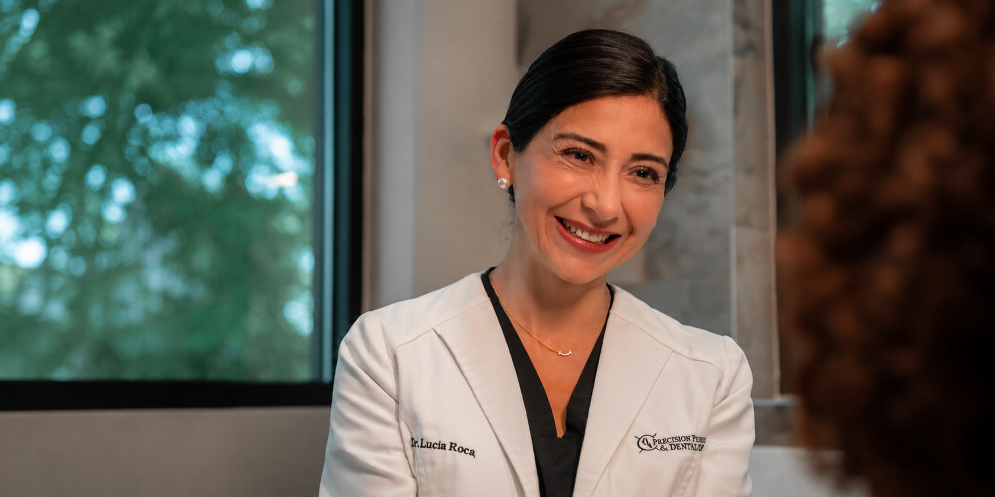 Dr. Lucia Mendro smiling at a patient in the chair